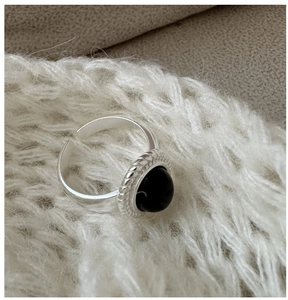 Macro shot of 925 sterling silver ring with oval black onyx and twisted rope frame