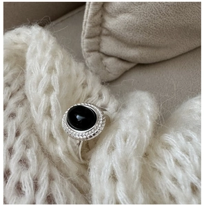 Close-up of vintage 925 silver ring with oval black onyx and rope edge detail