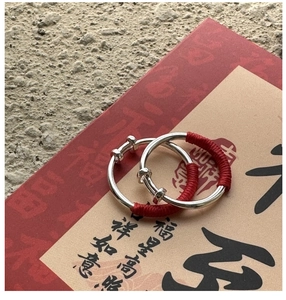 Detailed macro of adjustable S925 silver baby bracelets with traditional red braided rope