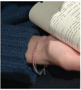 Detail of S925 silver layered bracelet with red stones and zircon on wrist