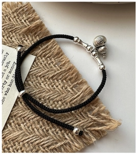 Détail macro de la gourde en argent S925 et bambou sur bracelet en corde tressée noire