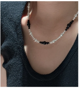 Detail of S925 silver beaded necklace with black onyx beads on a female neck