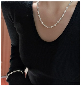 Close-up of 925 sterling silver beaded necklace and bracelet set on a female model