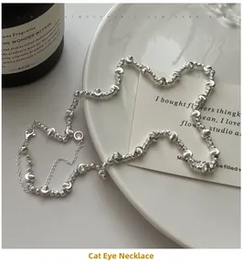 Detailed view of silver cat eye necklace with helical beads and half-moon components
