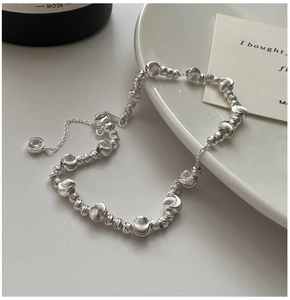 Detail of S925 silver bracelet featuring textured beads and a zircon stone charm pendant