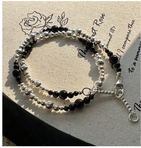Detailed macro view of S925 silver and black agate beaded necklace with lobster clasp