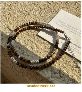 Detail of beaded tiger eye stone necklace with silver wire wrap and lobster clasp on stone