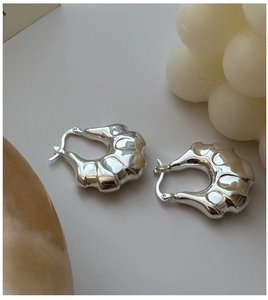Close-up of S925 sterling silver earrings showing the hallmark and wavy molten texture