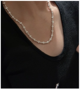 Macro detail of 925 silver beaded necklace with intricate spiral engraved textures