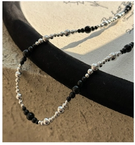 Close-up of S925 silver beads and black onyx stones on a minimalist gradient necklace