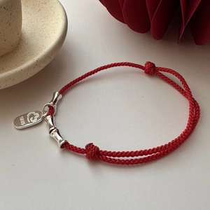 Red braided cord bracelet with S925 silver heart charm and bamboo joints in scene