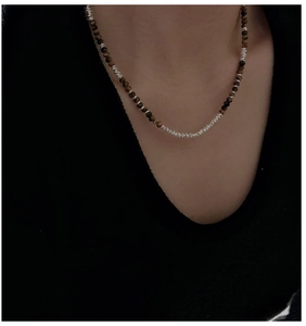 Detail of 925 silver necklace with brown tiger eye beads on a model collarbone