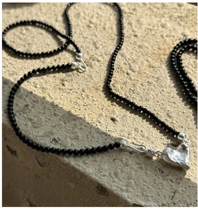 Detail of S925 silver clasp necklace with black onyx beads and irregular heart pendant