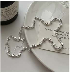 Detailed view of S925 silver beaded necklace with textured pattern on elegant background