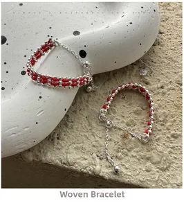 Detailed close-up of S925 silver beaded woven red string rings on a textured stone base