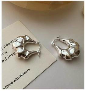 Detailed view of silver minimalist hoop earrings with modern liquid lava texture on card