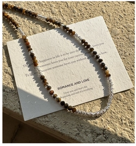 Detail of tiger eye stone beads and silver textured wire link necklace on card
