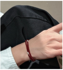 Close-up of double-strand red agate beaded bracelet with silver spacers on a model wrist