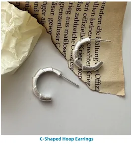 Close-up of S925 sterling silver C-shape earrings with a textured matte finish
