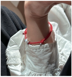 Details des roten gewebten Armbands mit Silberanhänger und verstellbarem Verschluss