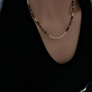 Vintage 925 silver necklace with tiger eye beads and metallic spirals on a female model