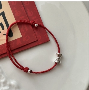 Detailansicht des handgefertigten roten Seilarmbands mit Silberschleife und Perlen