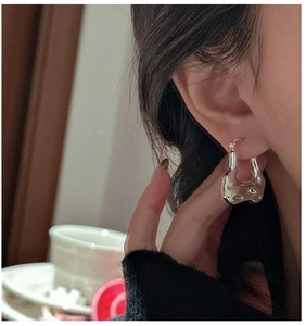 Detail of S925 sterling silver earring with liquid metal texture and organic shape