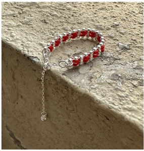 Macro shot of S925 sterling silver beads woven with red rope on an adjustable ring