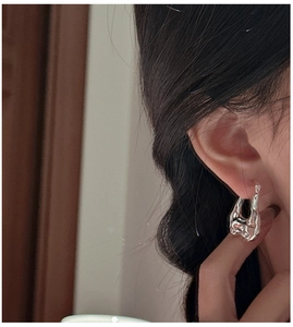 Detailed close-up of S925 silver earring with irregular liquid lava texture on ear
