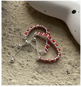 Detail of red braided silver bead ring with adjustable drawstring chain and smooth metal beads