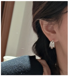 Close-up of S925 sterling silver triple-layered earrings with a molten metal texture