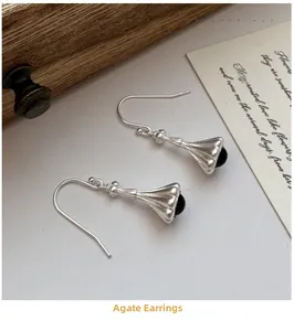 Detail of vintage S925 silver hook earrings with matte texture and black agate bead