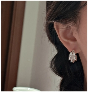 Close-up of S925 sterling silver triple-layered hoop earrings worn on a model ear