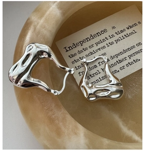 Macro detail of S925 sterling silver hoop earrings with a liquid metal texture