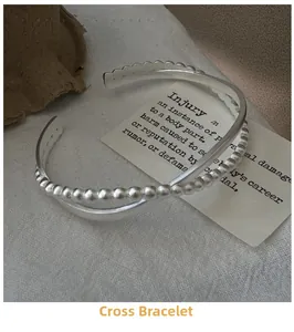 Close-up of S925 silver overlapping bangle featuring smooth and beaded texture layers