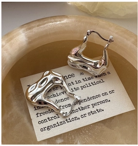 Macro view of S925 sterling silver hoop earrings with a modern lava-like wavy texture