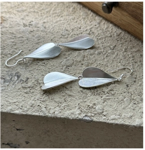 Detailed close-up of S925 sterling silver leaf earrings with a matte brushed finish