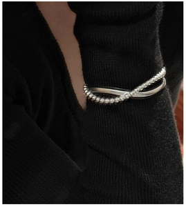 Detail view of S925 sterling silver layered cross bracelet with polished beads and sleek bands