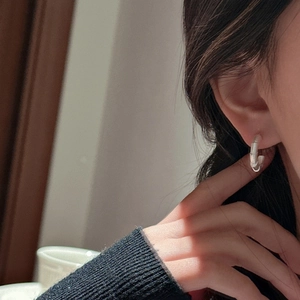 Minimalist S925 sterling silver hoop earrings with bamboo texture worn by a model