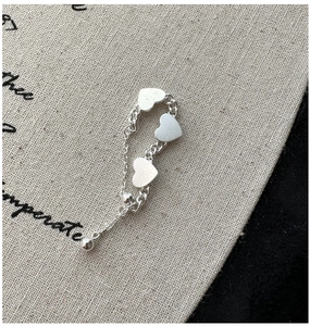 Détail d'une bague réglable en argent S925 avec trois breloques cœurs givrés sur une chaîne