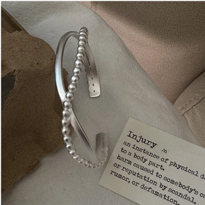 Detail of S925 sterling silver bangle with double-layer cross and beaded texture