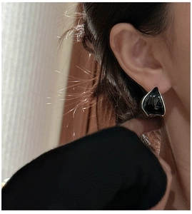 Gros plan de boucles d'oreilles minimalistes en émail noir avec bord argenté