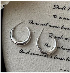 Gros plan de boucles d'oreilles créoles en C en argent S925 avec finition miroir polie