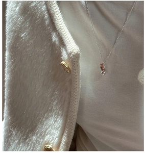 Close-up of 925 silver snowman necklace worn on neck with white knit sweater