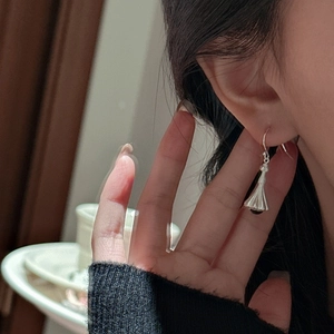 Elegant S925 sterling silver drop earrings with textured bell shape worn by a model