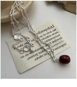 Detailed macro of a vintage S925 silver rope chain with an oval red agate stone pendant
