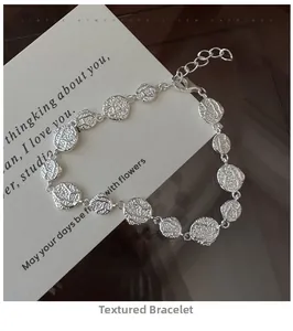 Detail of S925 sterling silver textured bracelet with irregular discs and lobster clasp