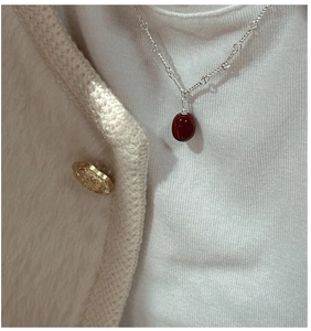 Close-up of S925 sterling silver heart-shaped chain with a deep red bead pendant