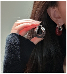 Détail de boucles d'oreilles en U en argent S925 et résine grise et marron foncé