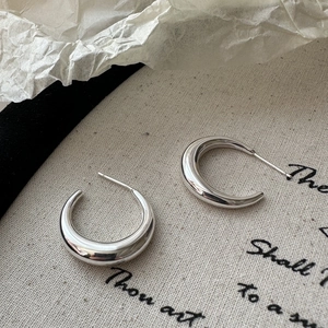 Boucles d'oreilles créoles en argent S925 poli sur fond de toile vintage minimaliste